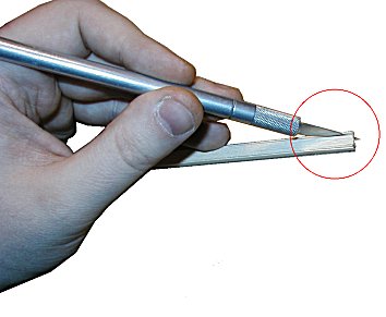 Én og en planke skjæres løs (papiret er limt mot den siden av stabelen som vender bort fra kamera)